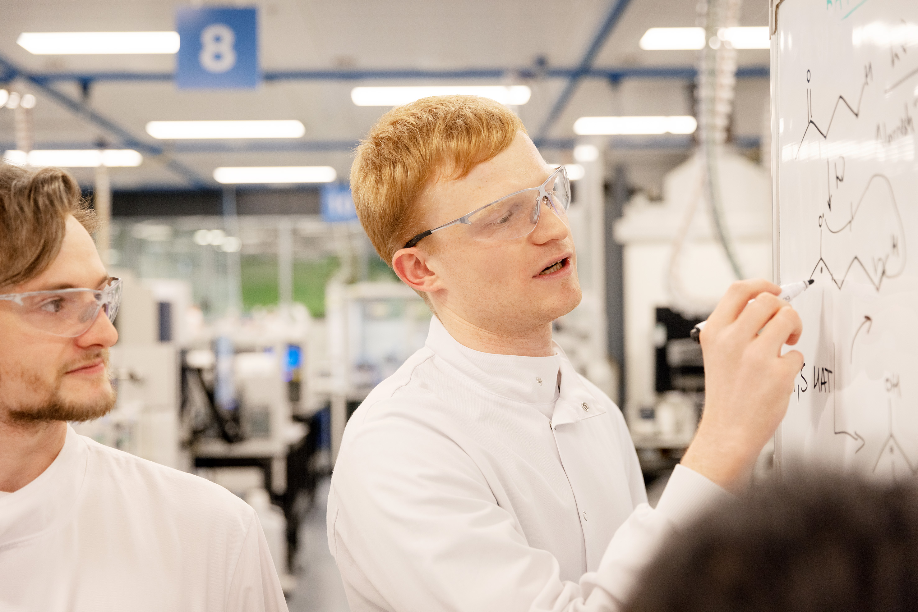 Scientist writing on whiteboard